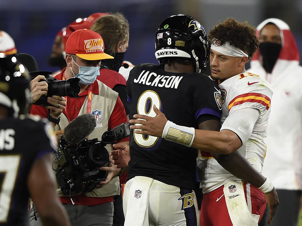Baltimore Ravens quarterback Lamar Jackson, center, and Kansas City Chiefs quarterback Patrick Mahomes, right, embrace after an NFL football game in 2020, in Baltimore. Jackson and Mahomes will face each other in the AFC championship game in Baltimore on Sunday.