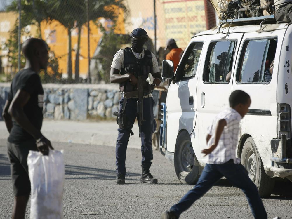 A police officer inspects a public transportation vehicle at a checkpoint in Port-au-Prince, Haiti, Friday, Jan. 26, 2024.