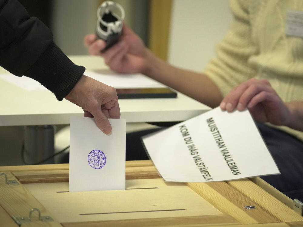 A woman casts her ballot at a polling station during presidential election in Helsinki, Finland, Sunday, Jan. 28, 2024.