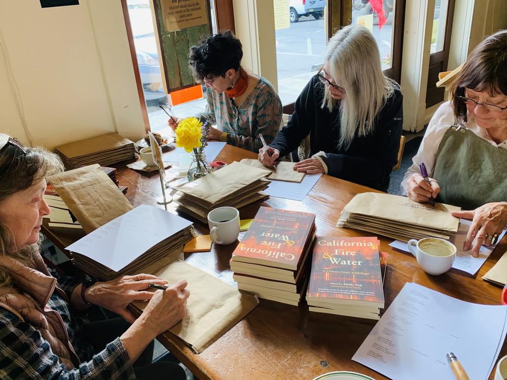 Judy Brackett Crowe, left, Janeen Singer, Kirsten Casey and Susanna Wilson mail out copies of Molly Fisk's <em>California Fire & Water: A Climate Crisis Anthology </em>in 2019. Both Fisk and Casey have served as poet laureate for Nevada County, Calif.