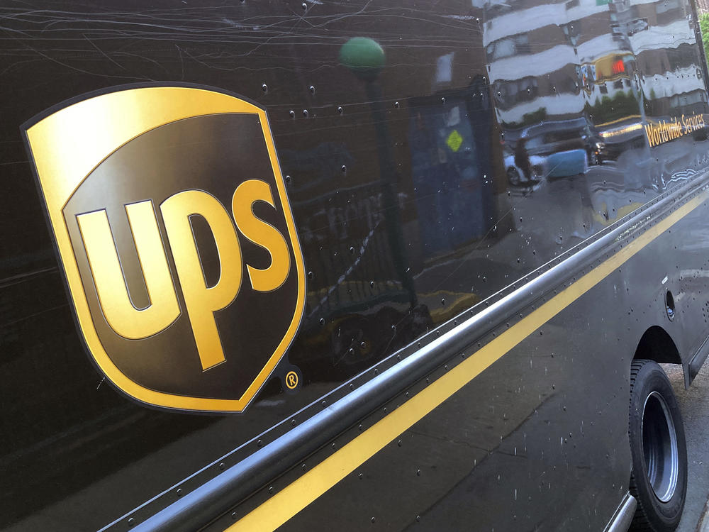 A UPS e truck is parked on a street in New York on May 11, 2023. On Tuesday, the company said it will cut 12,000 jobs.