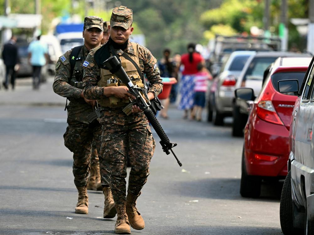Soldiers patrol during an operation against gang members in La Campanera, a community historically controlled by the 18th Street gang, in Soyapango, El Salvador, on Dec. 4, 2022.