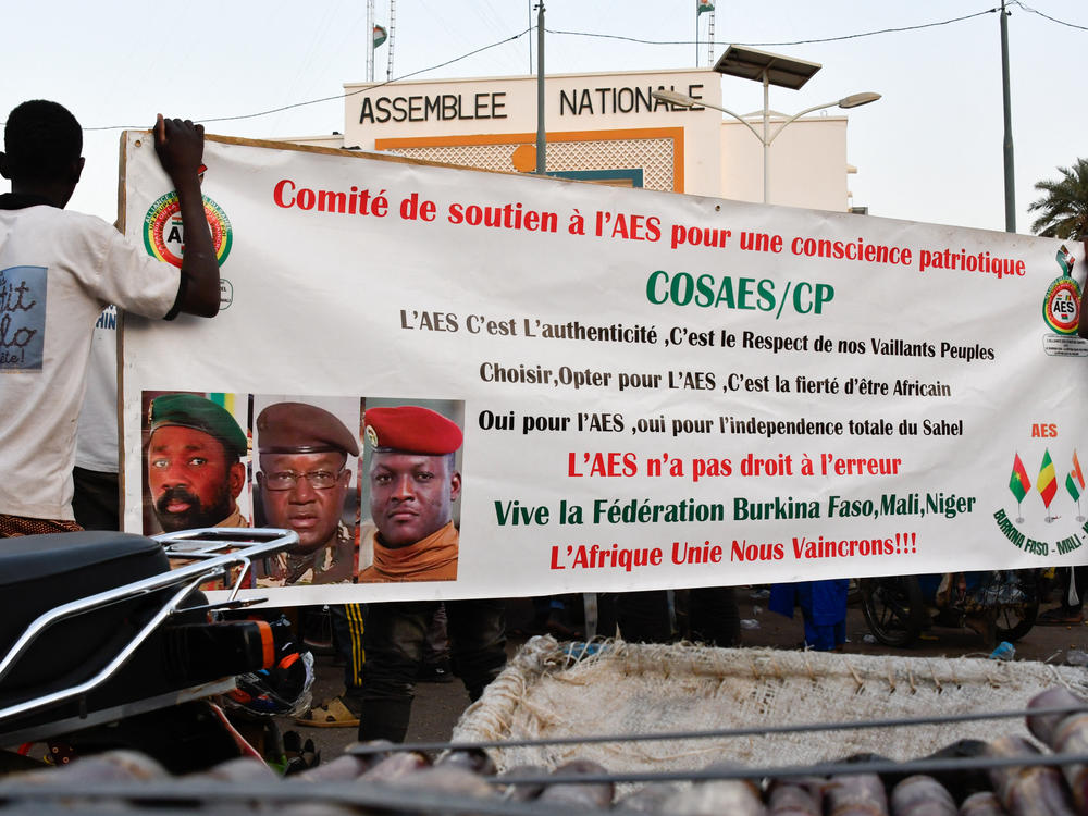 Supporters of the Alliance Of Sahel States (AES) hold up their banner as they celebrate Mali, Burkina Faso and Niger leaving the Economic Community of West African States (ECOWAS) in Niamey on January 28, 2024.