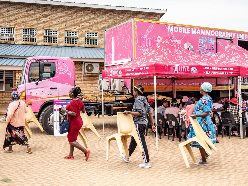 Patients carry chairs for their wait to be seen on screening day at a clinic in Johannesburg.