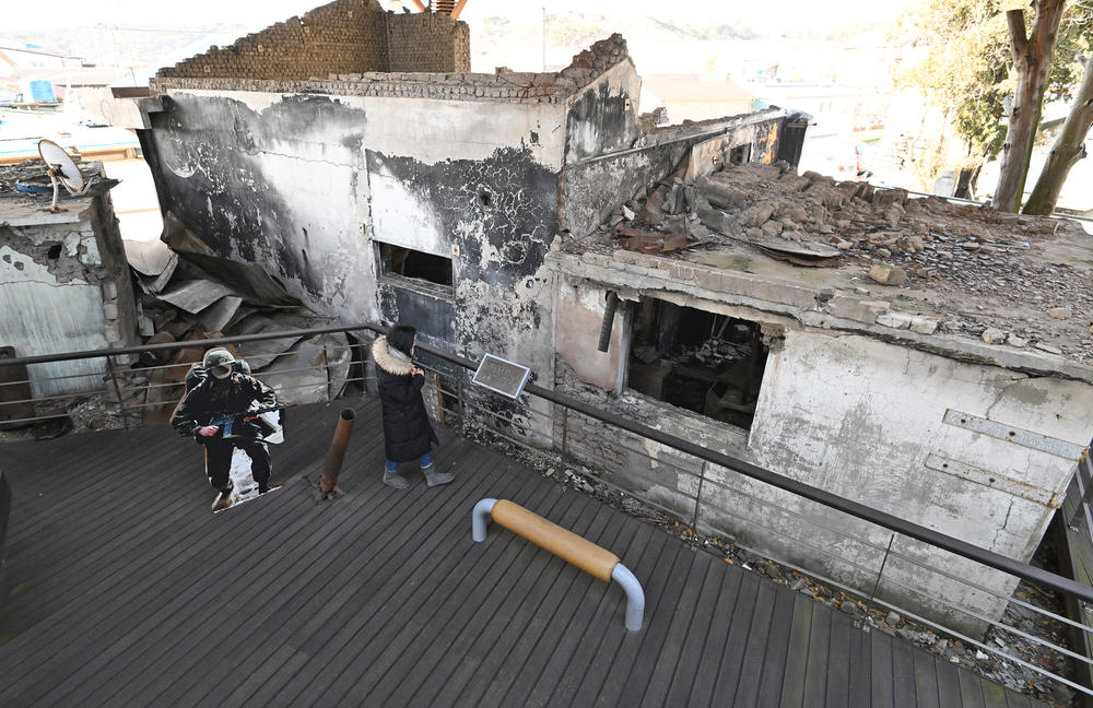 In January, a woman looks at wrecked homes hit by North Korea's 2010 shelling attack at a museum that displays materials related to the attack.