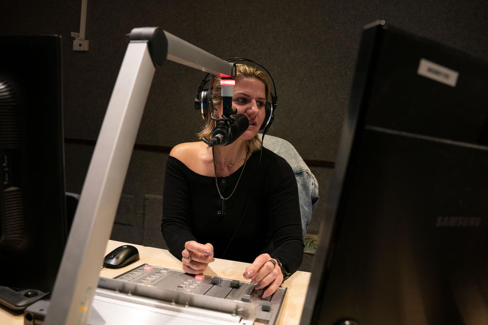 Radio host Hadar Marks speaks on air during Israel's top drive-time morning show on the country's most popular music channel, Galgalatz. She plays songs dedicated to Israeli hostages in Gaza. 