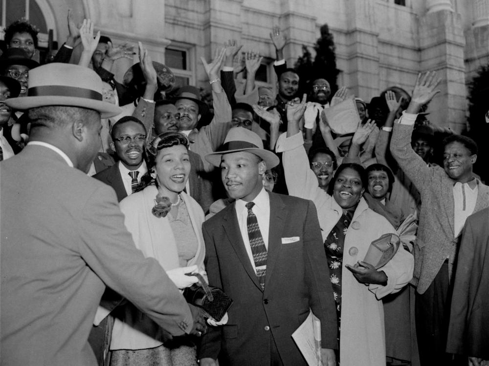 The Rev. Ralph Abernathy (left) shakes hands with the Rev. Martin Luther King Jr. in Montgomery, Ala., on March 22, 1956, as a big crowd of supporters cheers for King, who had just been found guilty of leading the Montgomery bus boycott.