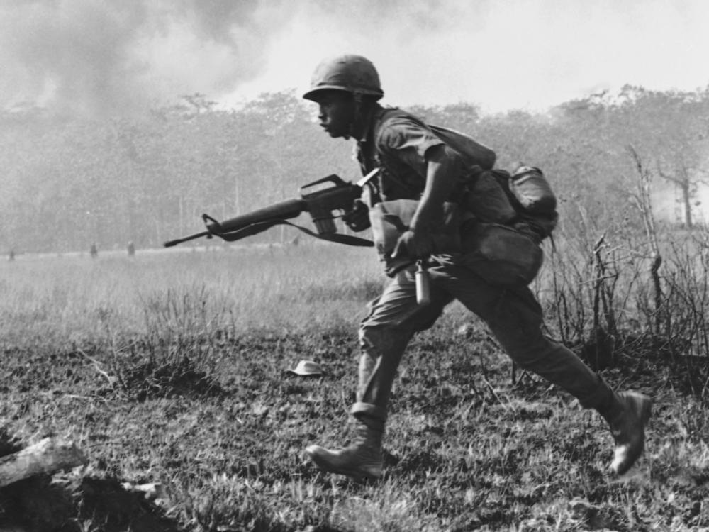 An infantry soldier runs across a burned-out clearing in Vietnam on Jan. 4, 1967.