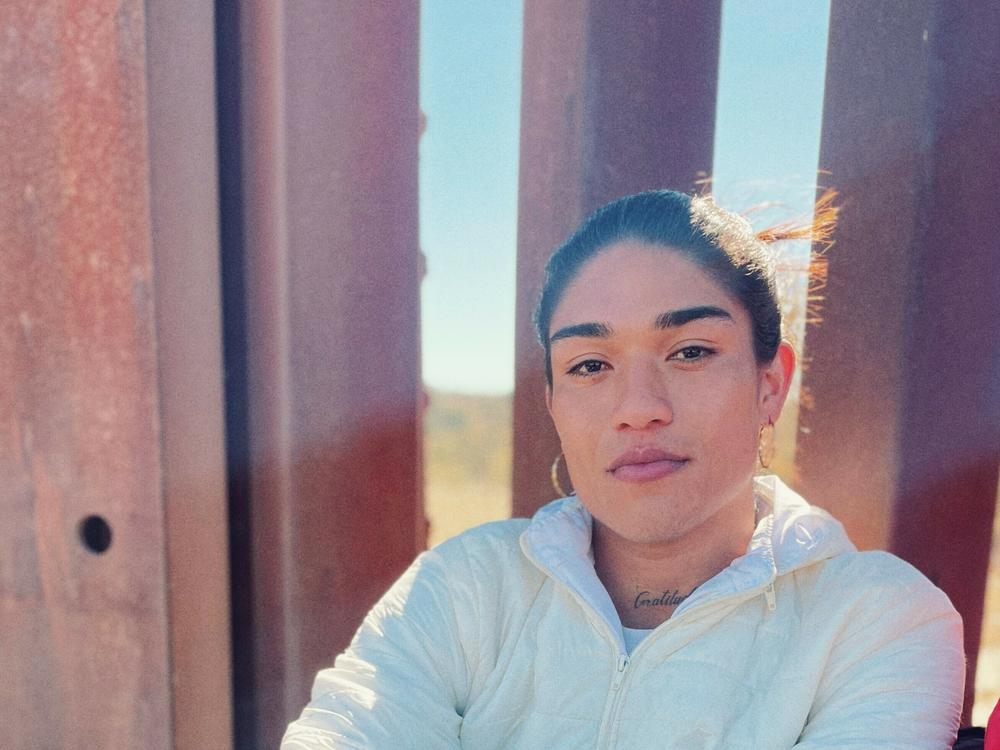 Dylan Villa, 22, is seen resting on the U.S.-Mexico border wall. Villa says she left Colombia to escape homophobia.