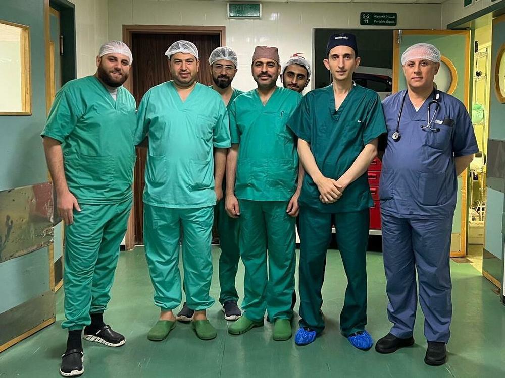 Dr. Husam Abukhedeir (second from right) stands with his neurosurgery team inside the operating room at Al-Shifa Hospital in Gaza in October.