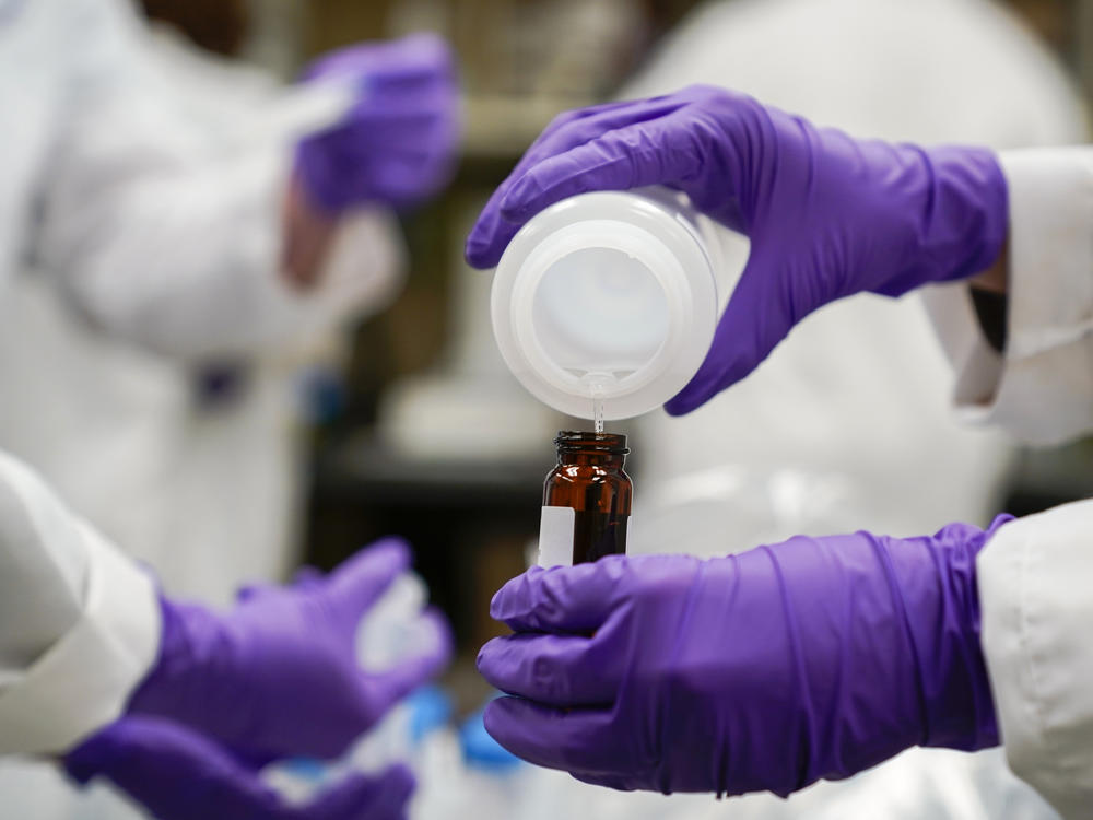 Eva Stebel, water researcher, pours a water sample into a smaller glass container for experimentation as part of drinking water and PFAS research at the U.S. Environmental Protection Agency Center For Environmental Solutions and Emergency Response, Feb. 16, 2023, in Cincinnati.