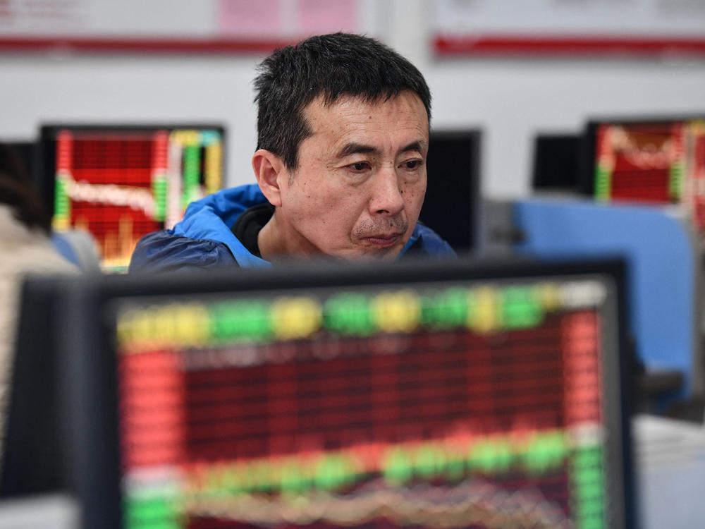 An investor looks at screens showing stock market movements at a securities company in Fuyang in China's eastern Anhui province on Jan. 17.
