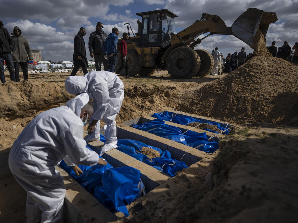 Palestinians bury the bodies of people who were killed in fighting with Israel and returned to Gaza by the Israeli military, during a mass funeral in Rafah, in southern Gaza, on Tuesday, Jan. 30.