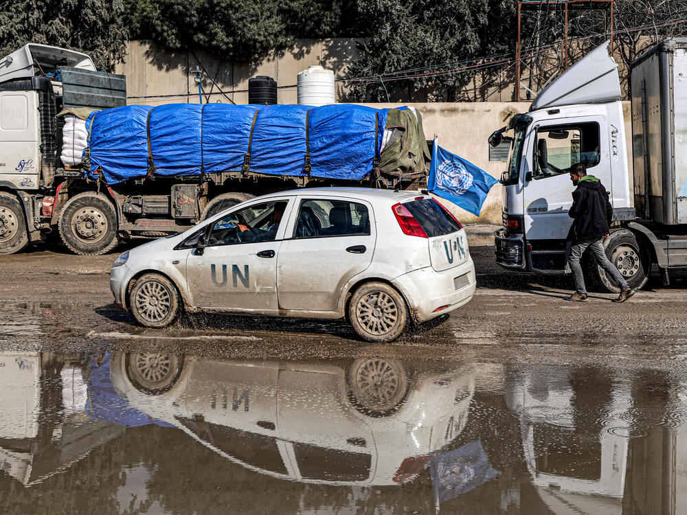 A U.N. vehicle moves past trucks carrying humanitarian aid entering the Gaza Strip through the Kerem Shalom border crossing in the southern part of the Palestinian territory on Monday, Jan. 29.
