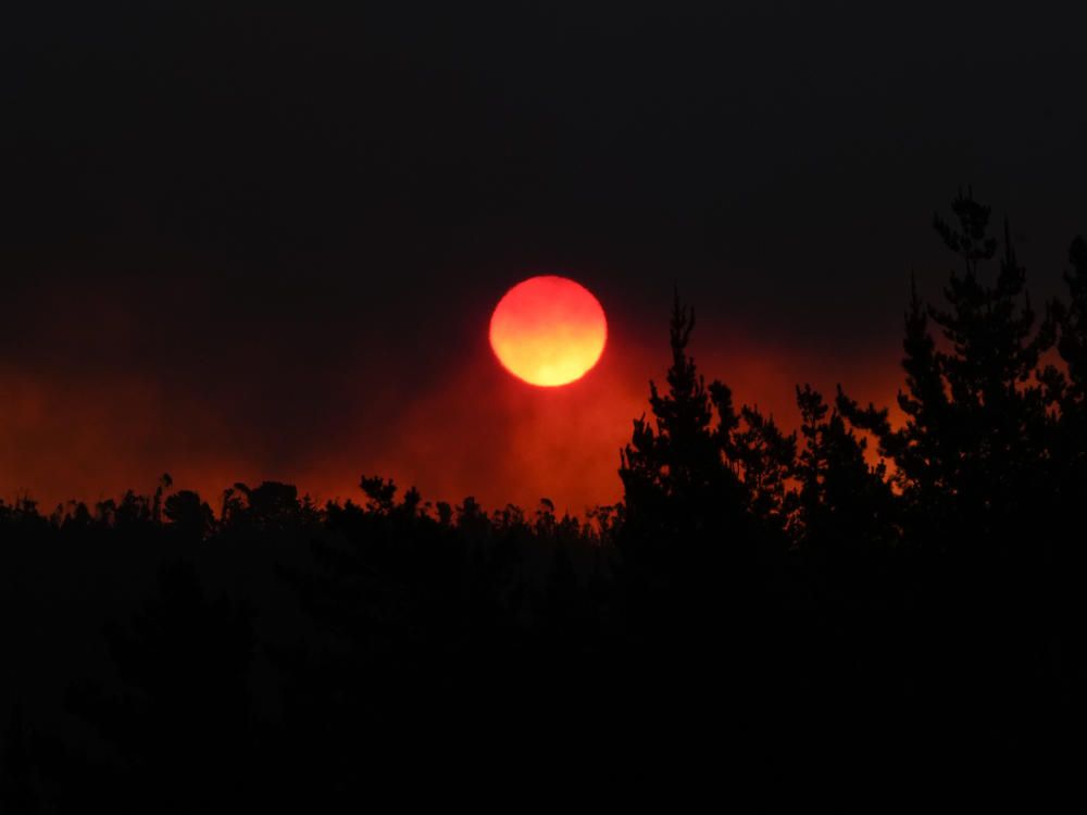 The sun sets as smoke fills the sky caused by the forest fire encroaching on Vina del Mar, Chile, on Saturday. Officials say intense forest fires burning around a densely populated area of central Chile have left dozens of people dead and destroyed hundreds of homes.