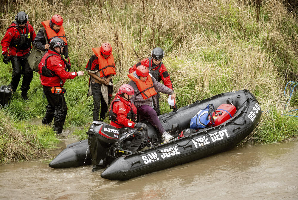 San Jose: Search and rescue workers evacuate men from a homeless encampment that became surrounded by floodwater from the Guadalupe River on Sunday.
