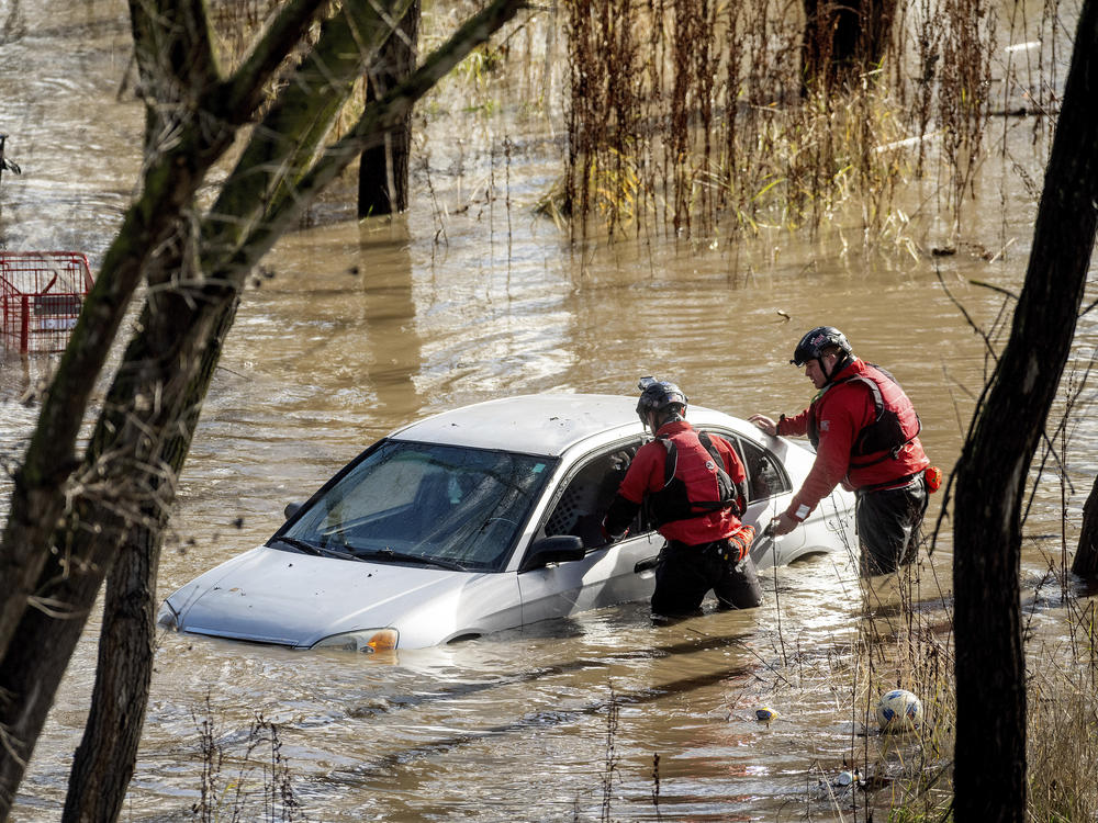 San Jose: Search and rescue workers check a car trapped in flooding after heavy rain caused the Guadalupe River to overflow its banks, Sunday.