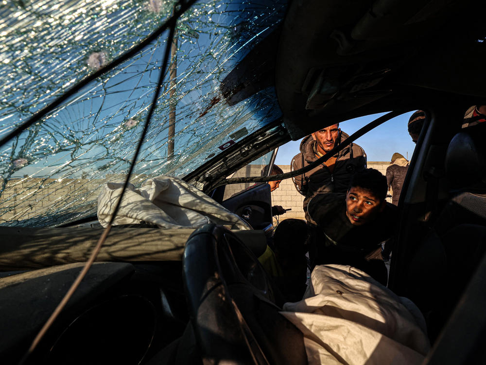 People check a damaged car in which three people were reportedly killed when it was hit by an Israeli strike in Rafah, in southern Gaza, on Wednesday, Jan. 31.