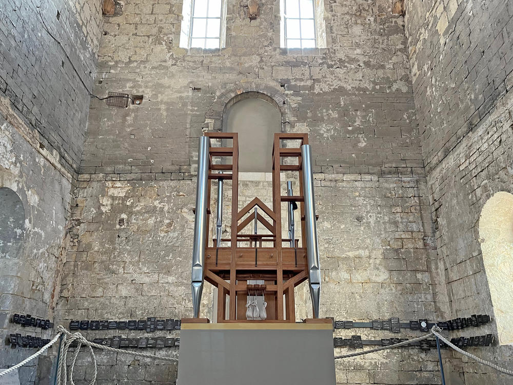 The wooden-framed organ that has played the composition since 2001 is a work in progress. It's being built as the piece goes on, with metal pipes added or taken away with each chord change. Its bellows, sitting across from the organ on a platform, are powered electrically, the wind from them carried to the organ through an underground pipe.