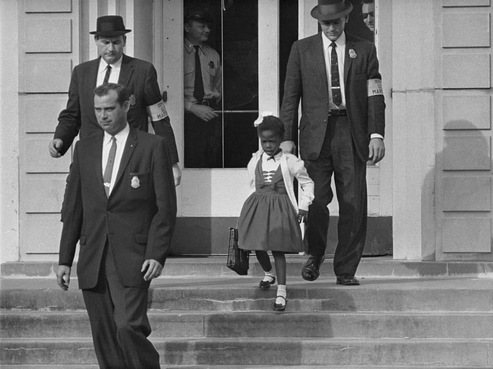 U.S. deputy marshals escort 6-year-old Ruby Bridges from William Frantz Elementary School in New Orleans in November 1960. The first-grader was the only Black child enrolled in the school, where parents of white students were boycotting the court-ordered integration law and were taking their children out of school.