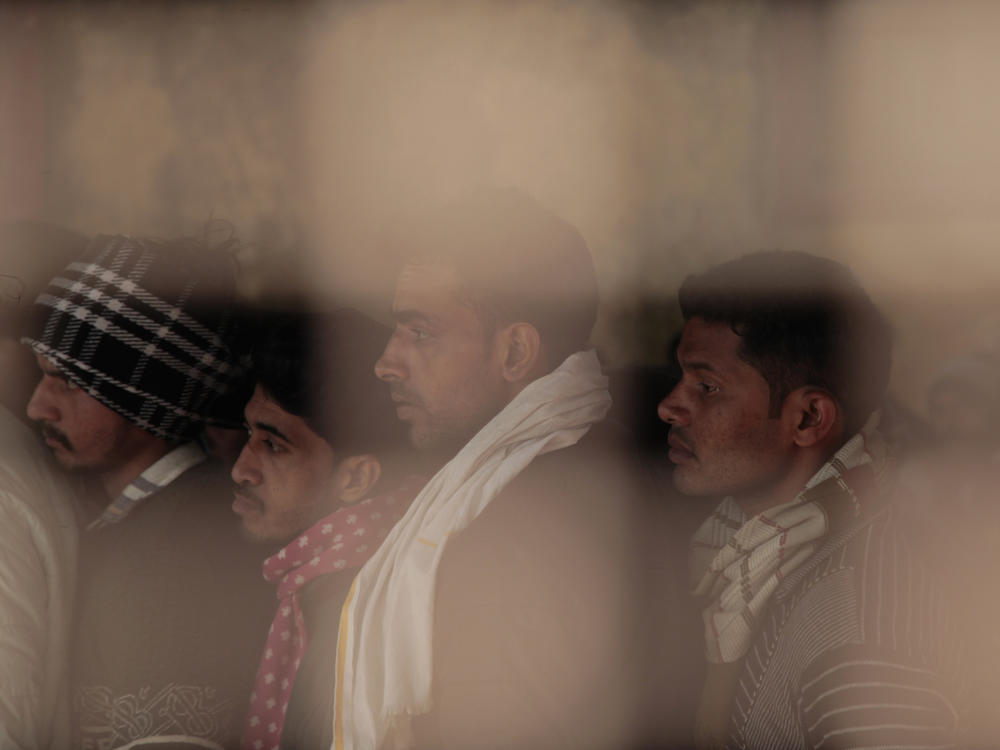 Indian men line up at a registration office set up in a technical college in the northern Indian city of Lucknow, where they hope to sign up to work in Israel.