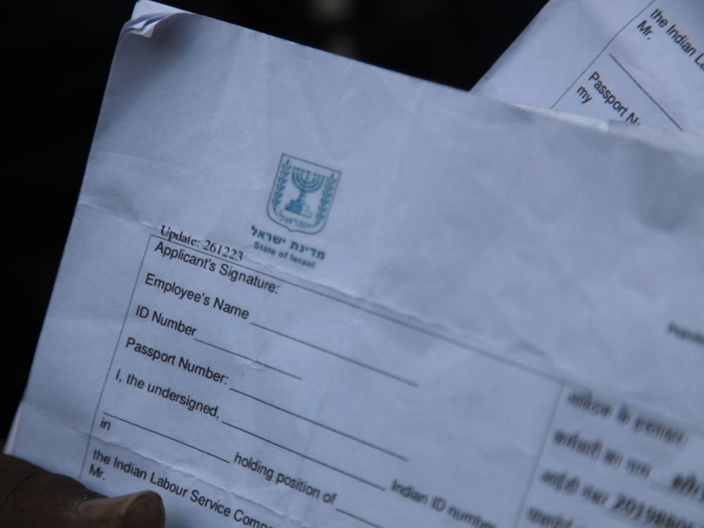 An Indian man holds up a registration form to work in Israel. He was recently at a registration office in the northern Indian city of Lucknow after two Indian states, Haryana and Uttar Pradesh, recently announced they were seeking to recruit 10,000 skilled laborers each to Israel.