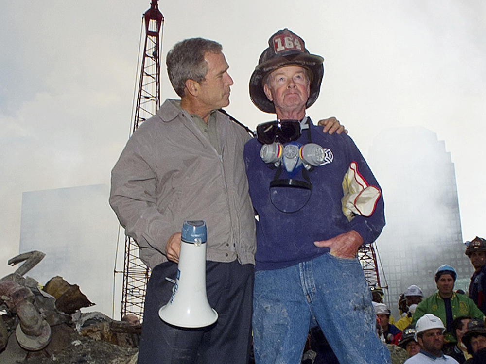 Then-President George W. Bush is shown with New York City firefighter Bob Beckwith on a burnt fire truck in front of the World Trade Center during a tour of the devastation, Sept. 13, 2001.