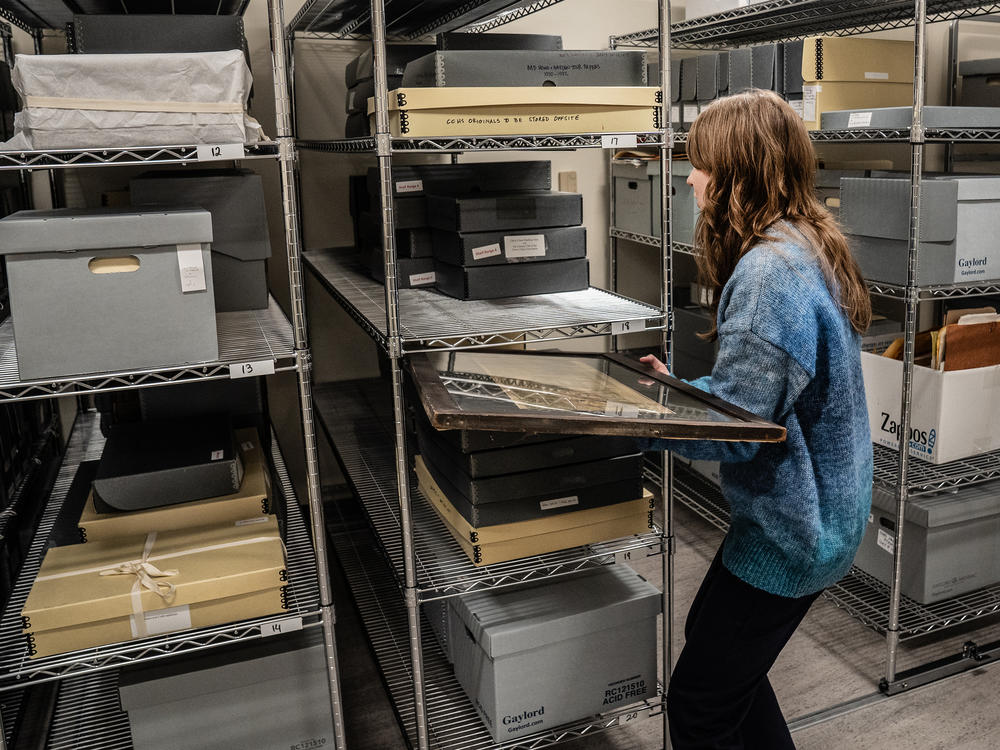 Lisowski moves some of the historical artifacts in a storage room.