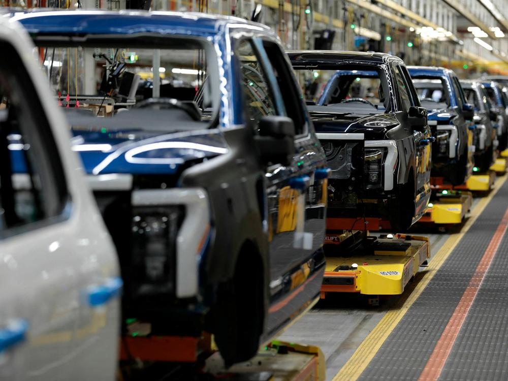 Electric F-150 Lightning pickup trucks travel down the production line at Ford's Rouge Electric Vehicle Center in Dearborn, Michigan on September 8, 2022. Ford has cut two shifts at the plant as it reduces production of the Lightning. But this week Ford CEO Jim Farley told investors 