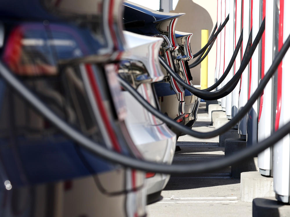 Teslas recharge at a Tesla Supercharger station in Burbank, Calif., in January. Access to charging is a major concern of many would-be electric vehicle chargers. A number of automakers are adopting Tesla's technology — and getting access to its reliable Supercharger network — in hopes of winning those car shoppers over.
