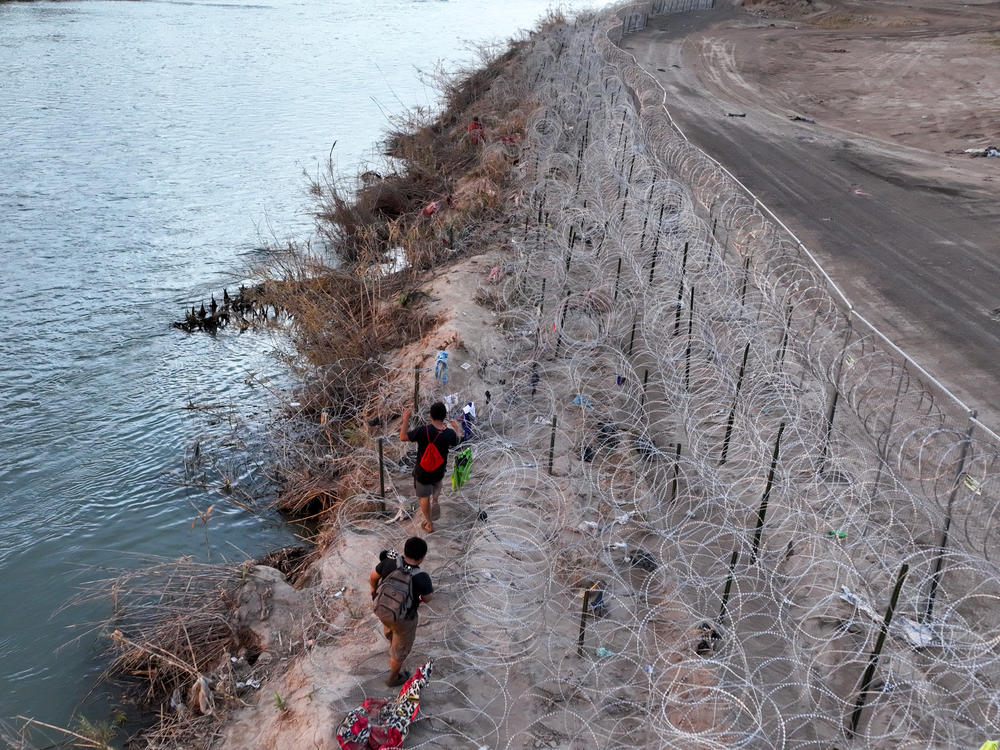 An aerial view of migrants walk next to razor wire as they try to cross Texas border in El Paso, Texas this week to seek humanitarian asylum.  Meanwhile a bill aimed at overhauling immigration is on the verge of collapse in Washington.