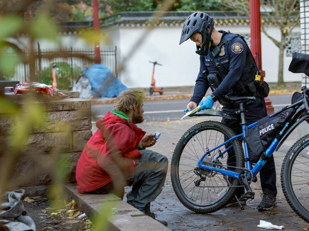 Officer Yoo gives a citation to a man he stopped for using fentanyl in public. Yoo said handing out citations doesn't appear to move people from using drugs on the streets into treatment programs.
