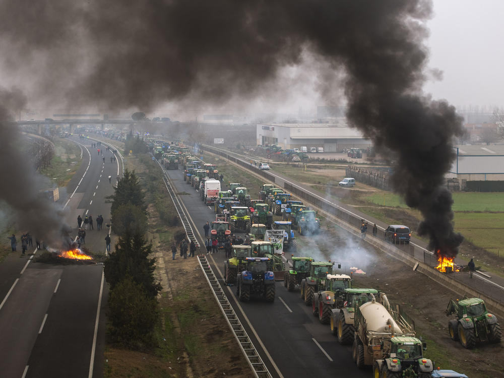 Farmers make barricades after blocking a highway during a protest near Mollerussa, northeast Spain, Tuesday, Feb. 6, 2024.