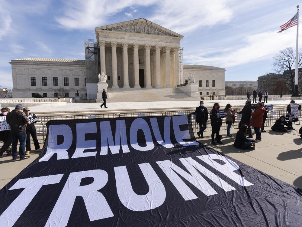 A banner is displayed in front of the U.S. Supreme Court on Thursday as justices prepared to hear arguments in a case about whether former President Donald Trump can be disqualified from state ballots. The case has profound implications for the 2024 presidential election.