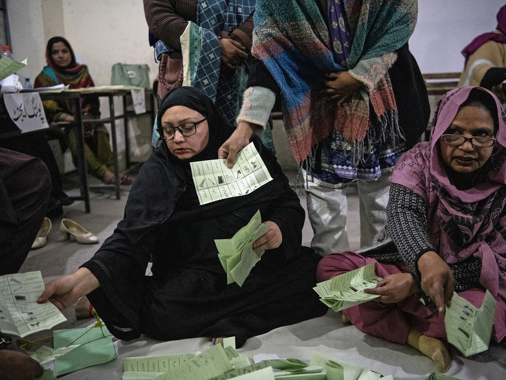 Pakistani election workers sort ballot papers at the start of the vote count in Thursday's general elections, at a polling station in Lahore, Feb. 8.