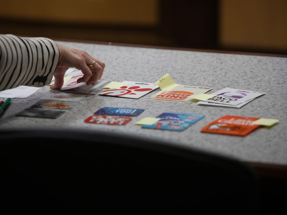 An assistant to Judge Sunny Bailey hands a young adult attending DAAY court a gift card to them for their good behavior.