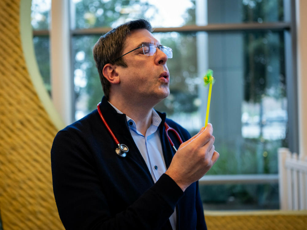 Dr. Stefan Friedrichsdorf demonstrates one of the distraction techniques he uses for children receiving shots at UCSF Benioff Children's Hospital in San Francisco on Dec. 18.