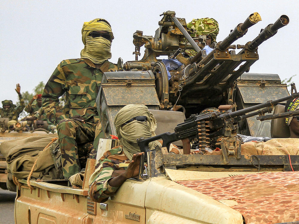 Fighters ride in a vehicle moving in a military convoy accompanying the governor of Sudan's Darfur State on Aug. 30, 2023.