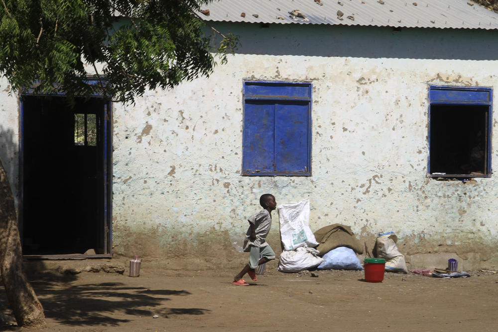 A child displaced from Sudan's Jazira state runs in front of a temporary shelter in Gedaref in the country's east on Dec. 28, 2023.