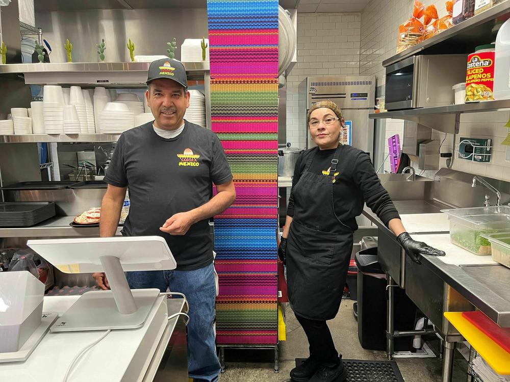 Luis Manuel Gama Mojica (left) and chef Blanca Sanchez stand in the kitchen of the taco restaurant owned by his daughter. Gama Mojica says the economy is one of the most important issues to him.