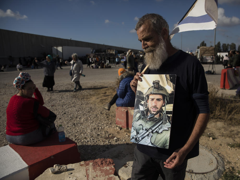 Yoel Kadish holds a photo of his cousin, Or Yosef Ran, who was killed in Hamas' Oct. 7 attack, as protesters block humanitarian aid from reaching Gaza on Tuesday, Feb. 6, in Kerem Shalom, Israel.