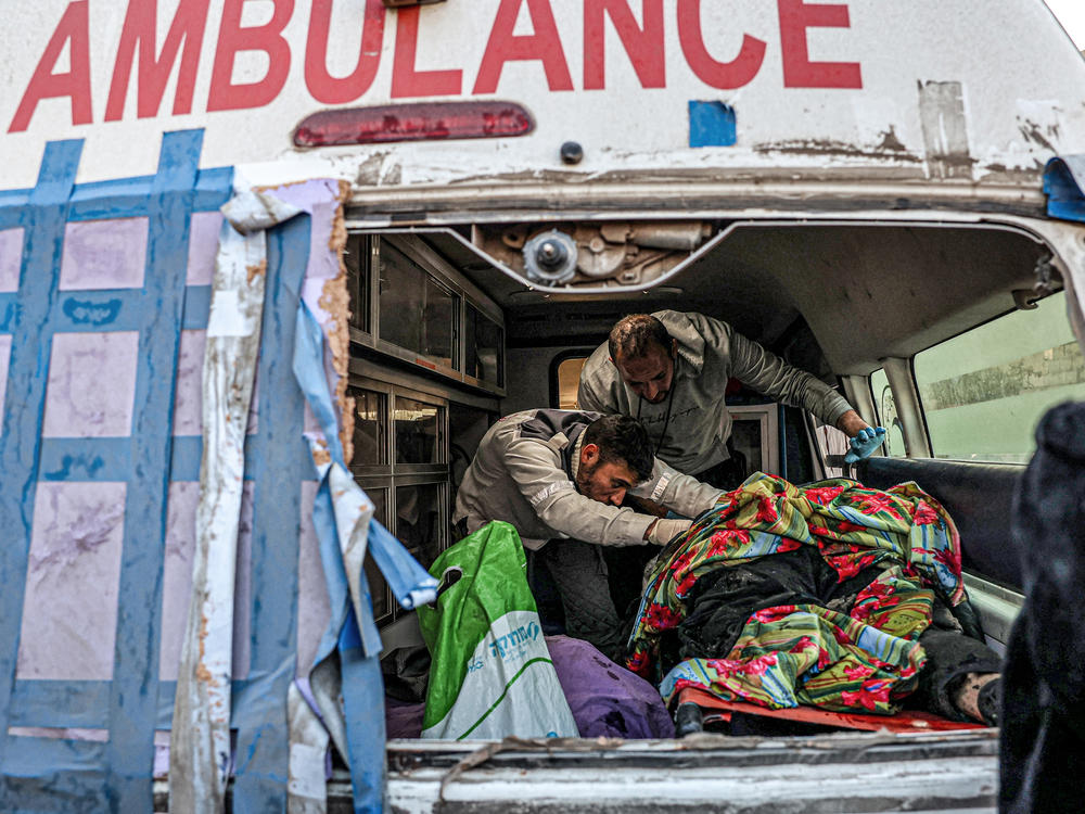 Palestinian paramedics load bodies recovered from a wrecked car into an ambulance following reports of an Israeli bombardment on Rafah on Tuesday, Feb. 6.