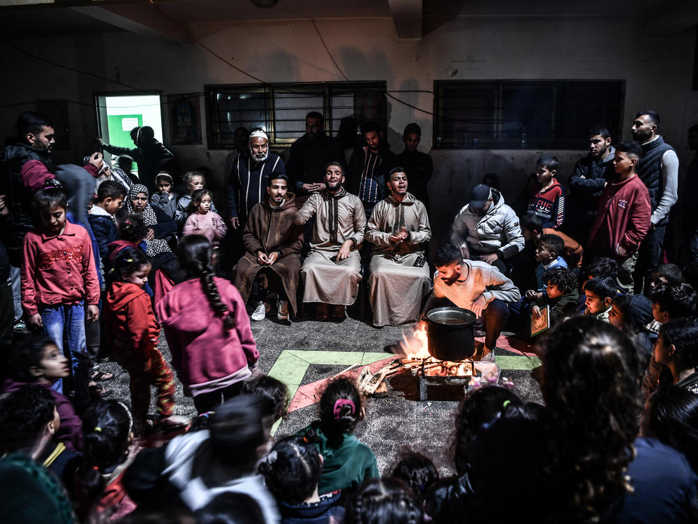 Palestinians who have fled their homes and taken refuge in a school to ensure their safety during Israeli attacks gather to celebrate Lailat al Miraj in Rafah on Thursday, Feb. 8.