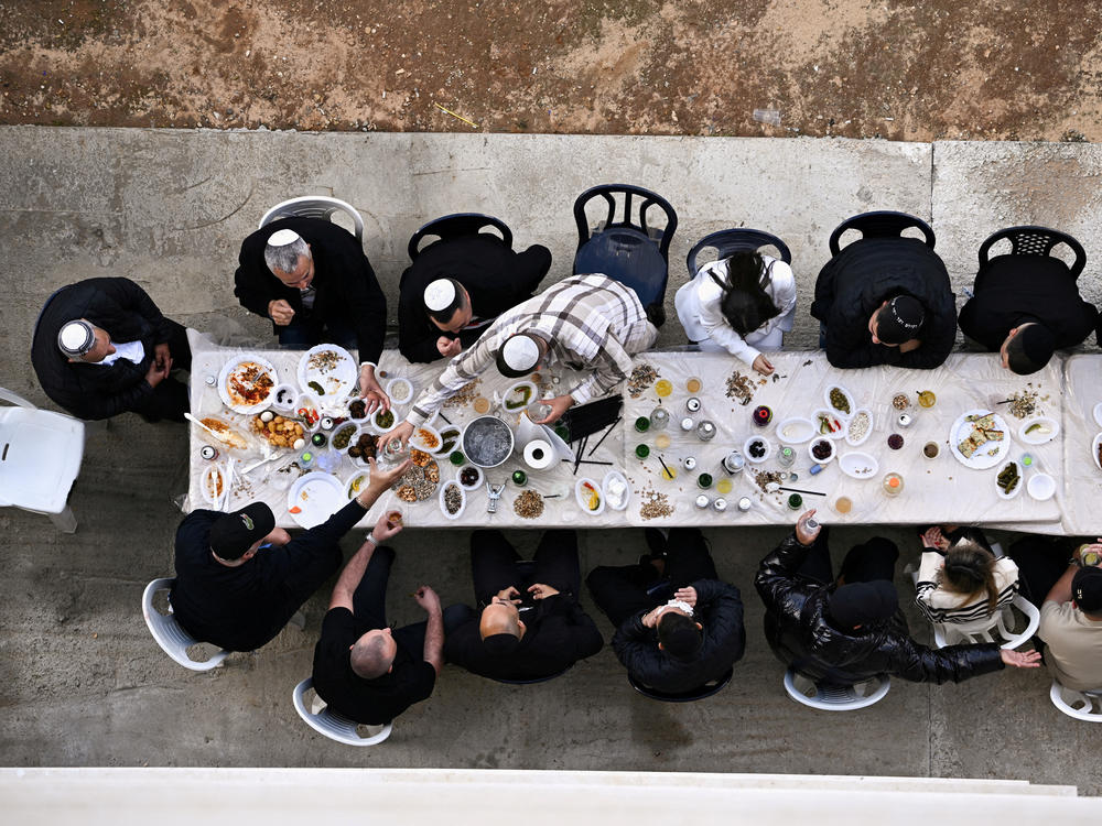 Friends and family share a Shabbat meal as people begin to return home in Sderot, Israel, on Saturday, Feb. 10.