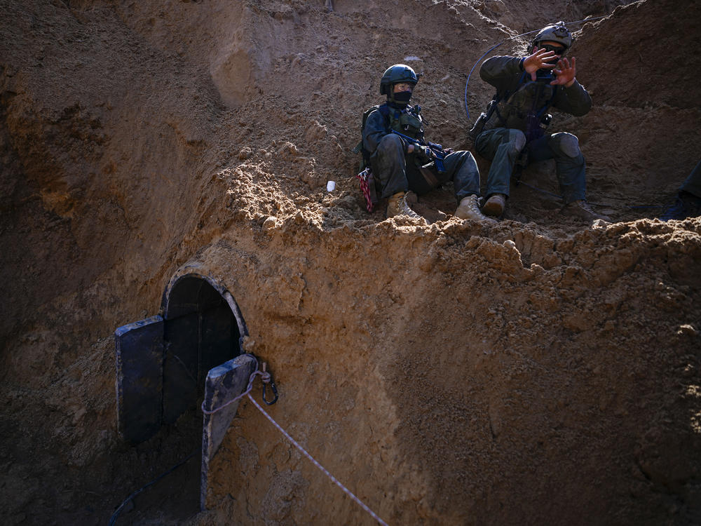 Israeli soldiers guard a crater-like hole giving way to a small tunnel entrance in an UNRWA compound on Thursday, Feb. 8, where the military discovered tunnels underneath the main headquarters of the U.N. agency that the military says Hamas militants used to attack its forces during a ground operation in Gaza.
