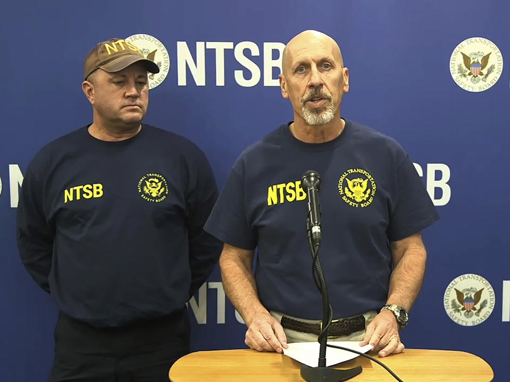 In this image taken from a National Transportation Safety Board video, Michael Graham of the NTSB, which is investigating a deadly helicopter crash that happened in Southern California's Mojave Desert speaks to the media in Barstow, Calif., Saturday, Feb. 10, 2024. The CEO of one of Nigeria's largest banks along with his wife and son were among those killed in Friday's crash.