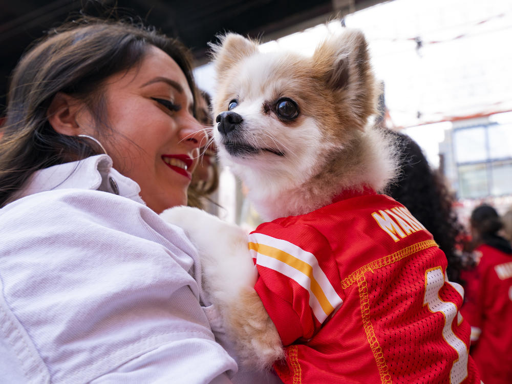 A dog dressed in a Patrick Mahomes jersey and its owner enter the Power and Light Entertainment District as fans prepare to watch the Kansas City Chiefs play the Philadelphia Eagles in the Super Bowl on Feb. 12, 2023 in Kansas City, Mo.