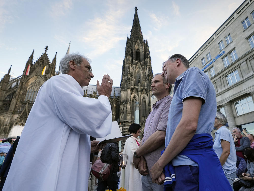 A same-sex couple receives a blessing in front of Germany's Cologne Cathedral in September 2023, a few months before Pope Francis officially declared such blessings allowable.
