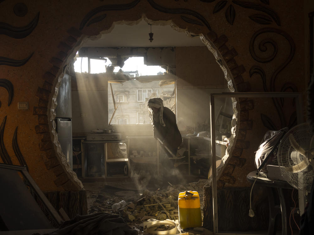 Palestinians look at their neighbor's damaged house following an Israeli strike in Rafah, southern Gaza Strip, Saturday, Jan. 27, 2024.