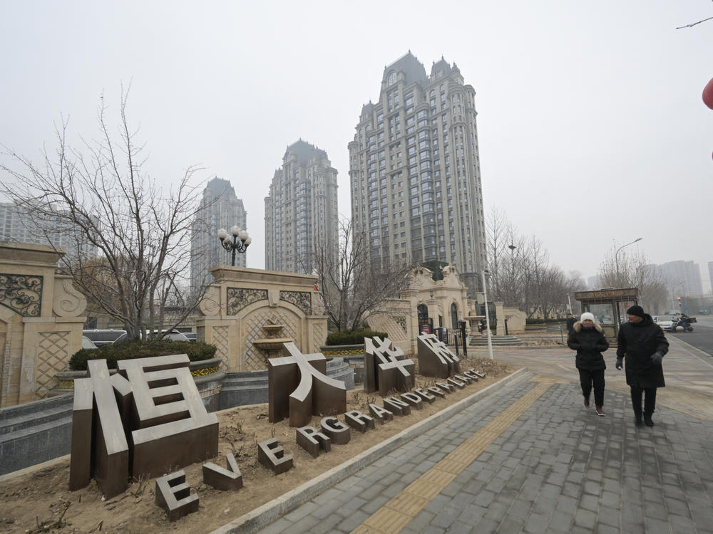 People walk past an Evergrande Group residential complex a day after a Hong Kong court ordered the liquidation of China's property giant Evergrande
